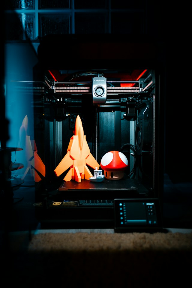 Prototipazione: stampante 3D con prototipi arancioni